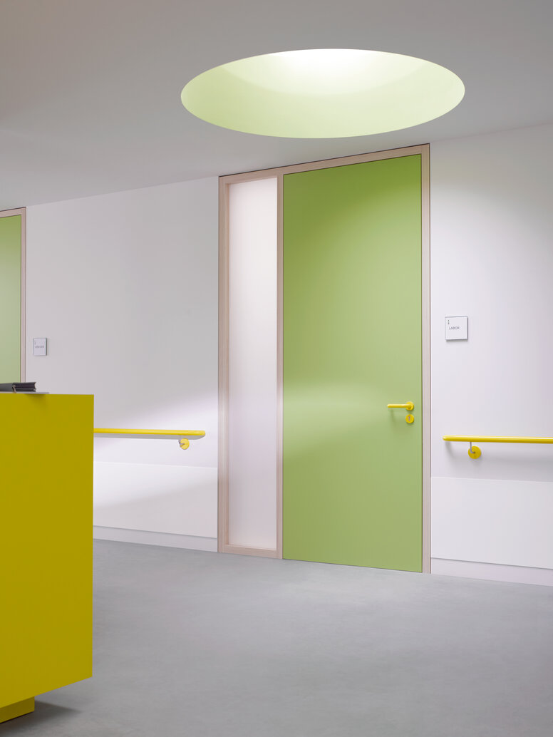 HEWI lever handle & handrail Green hallway door equipped with System 111 lever handle in the colour mustard yellow and handrail in the colour mustard yellow