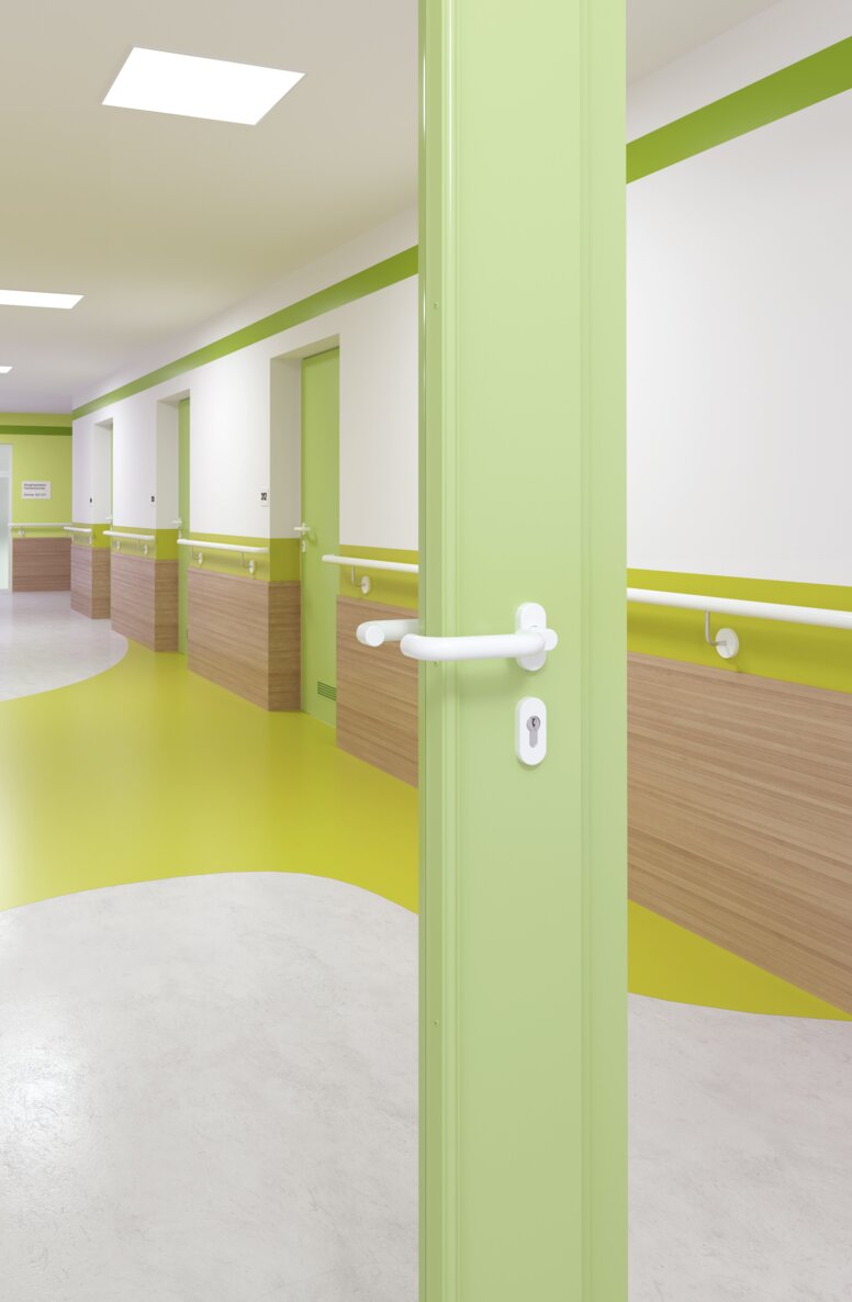 HEWI Türgriff Signalweiß Verglaste Krankenhaustür mit grünem Rahmen ausgestattet mit einem Türgriff in der Farbe Signalweiß aus Polyamid