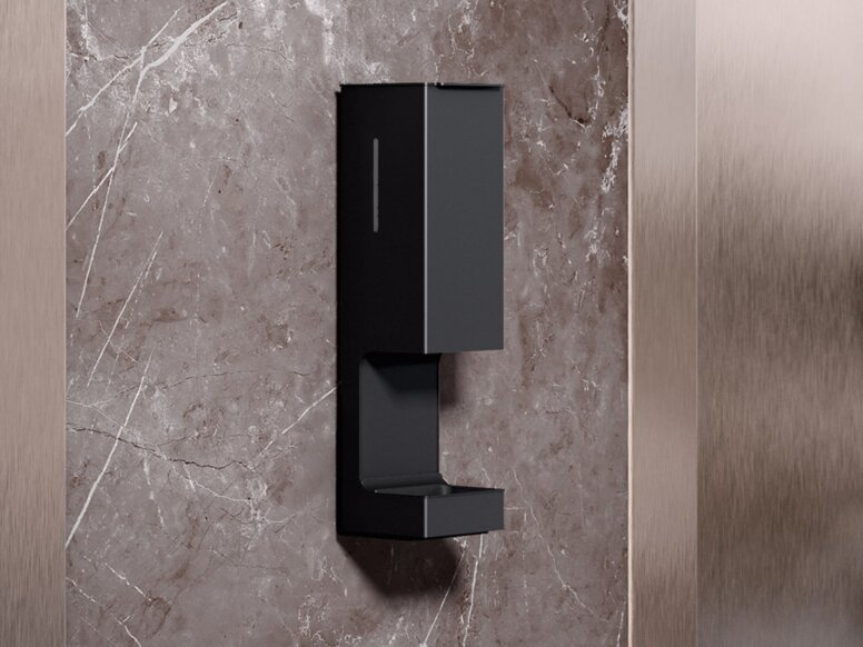 HEWI SENSORIC Desinfektionsmittelspender Wandmodell An der Wand zwischen zwei Aufzugtüren ist ein berührungsloser Desinfektionsmittelspender angebracht